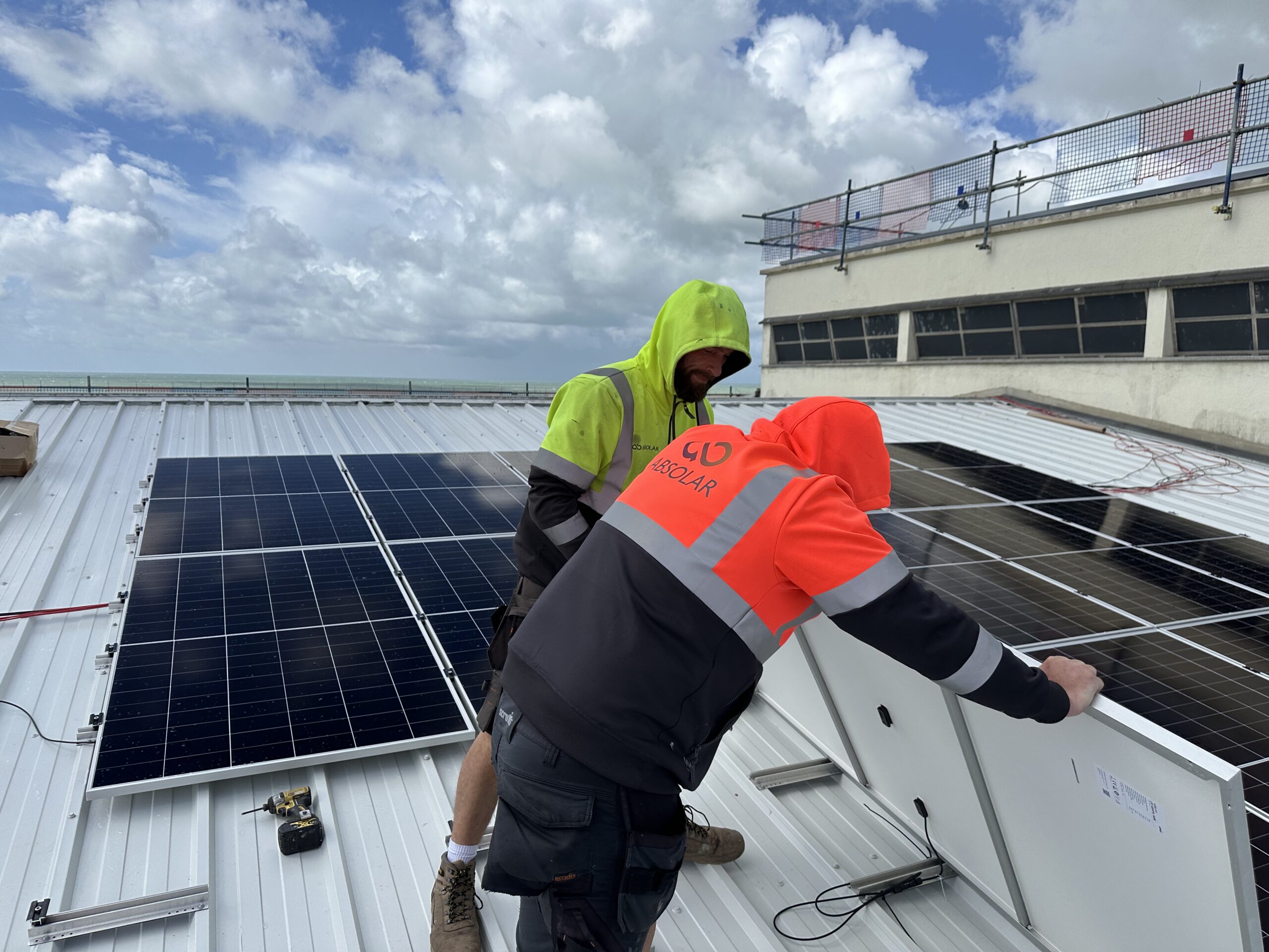 Contractors installing solar panels on roof of De La Warr Pavilion