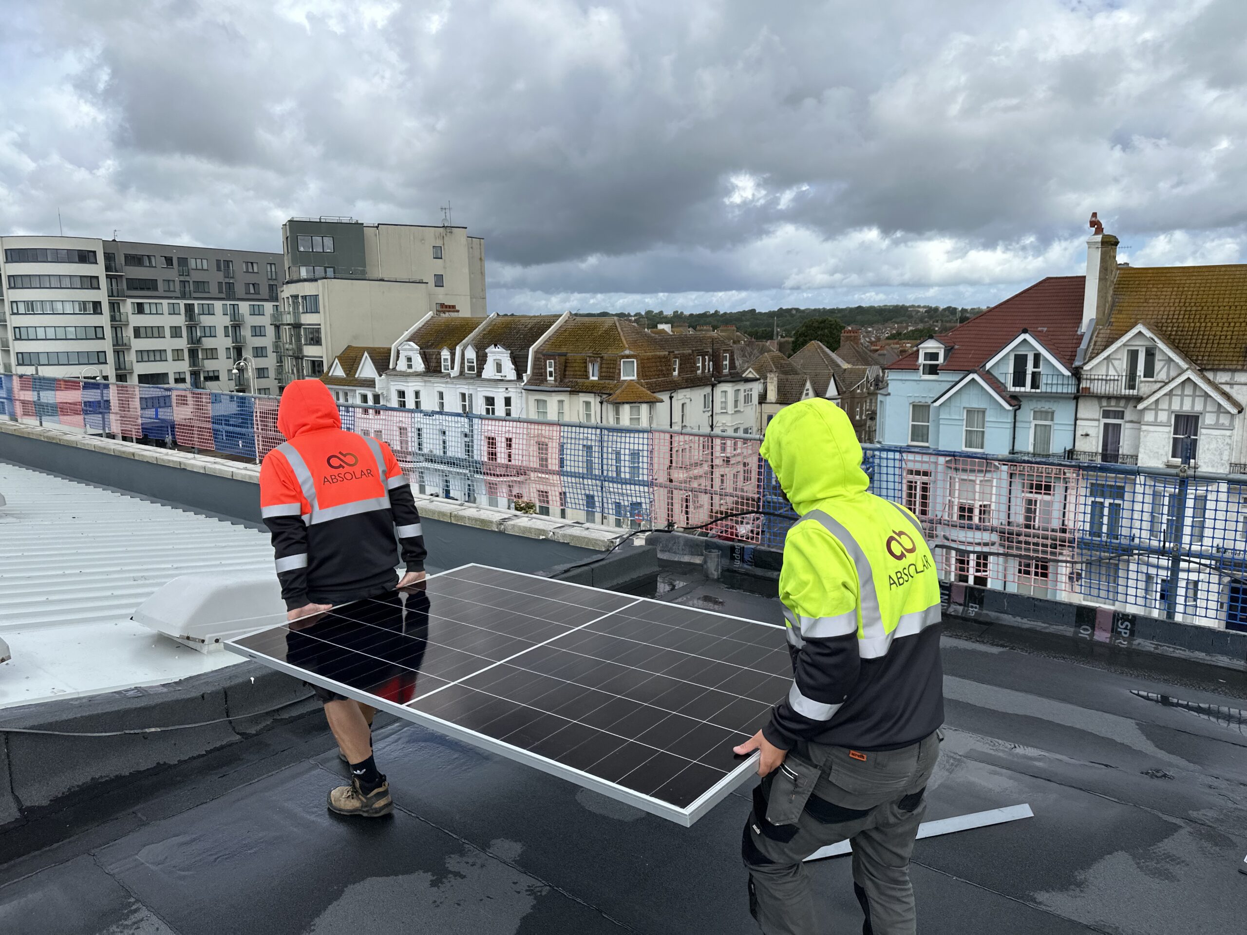 Contractors installing solar panels on roof of De La Warr Pavilion