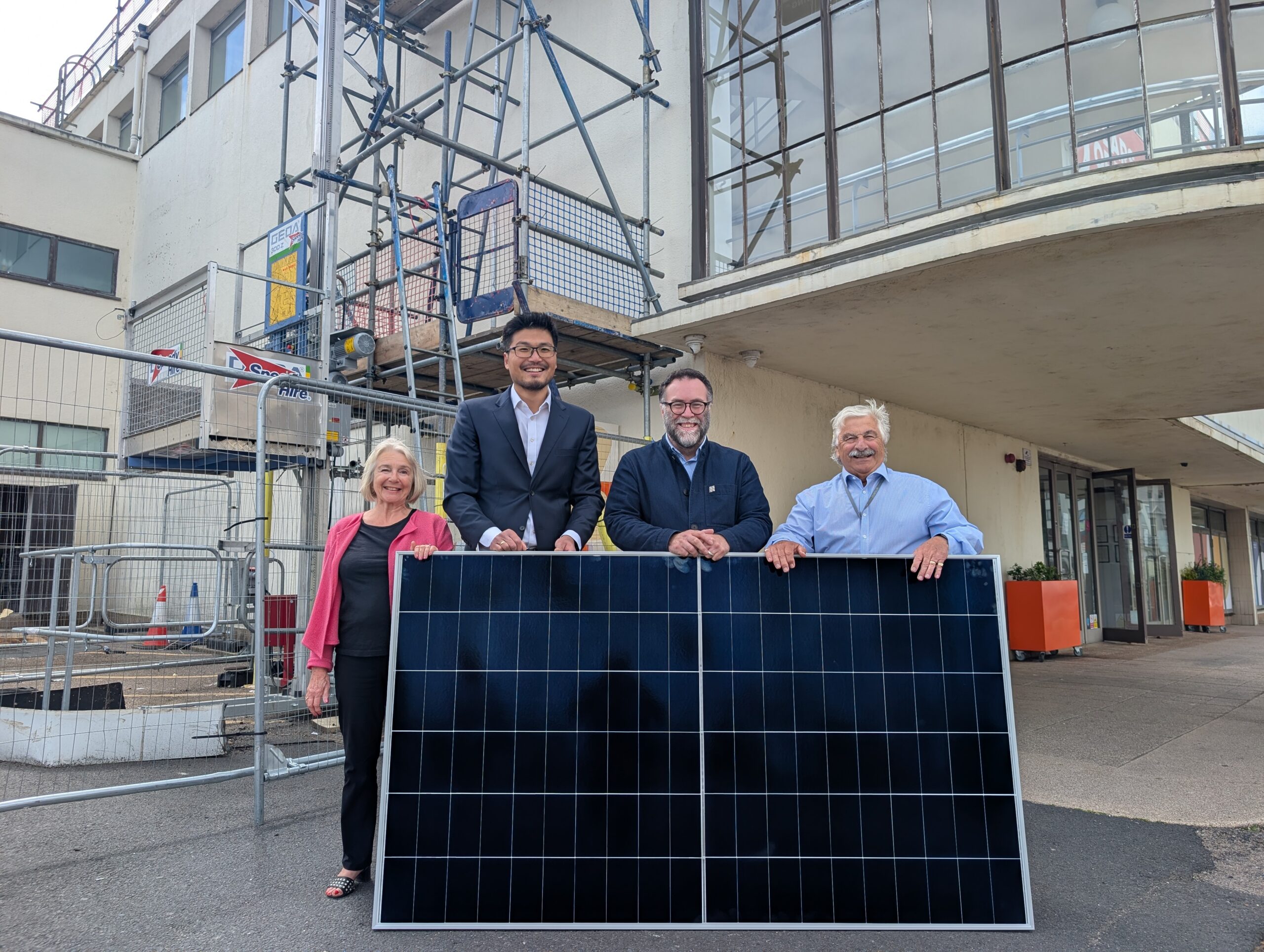 From left to right pictured Cllr Kathryn Field, Dr Phil Wu, Stewart Drew, Cllr Doug Oliver stood behind a solar panel in front of the De La Warr Pavilion